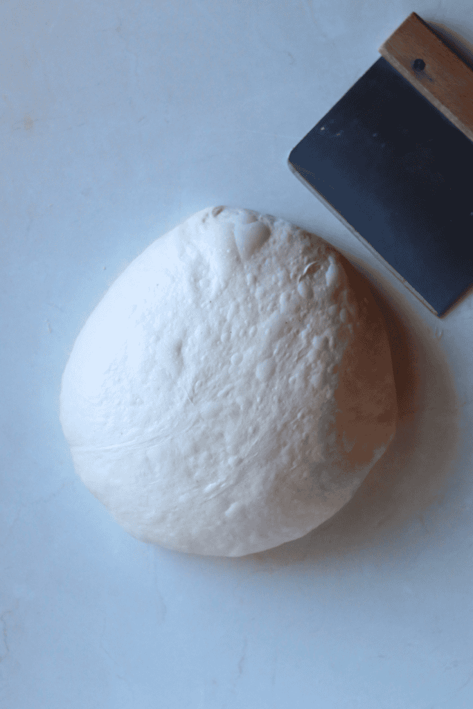 shaping the dough with a bench scraper