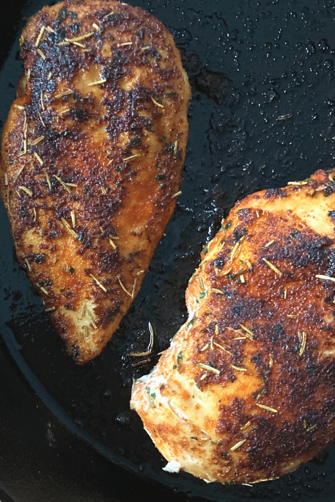 2 chicken breasts in a cast iron covered with a spice rub