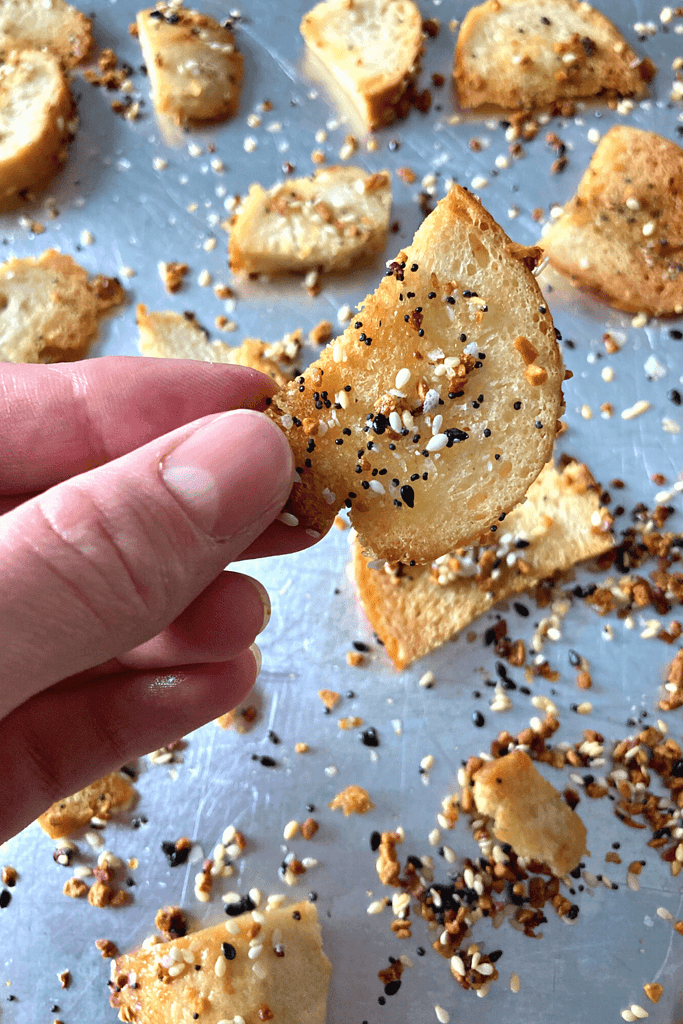 hand holding sourdough bagel chip with everything seasoning