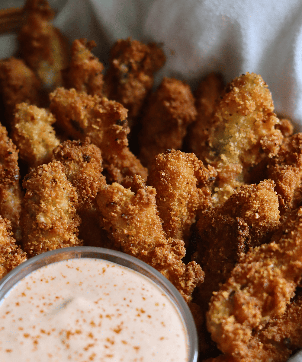 Sourdough fried pickles in a basket with dipping sauce