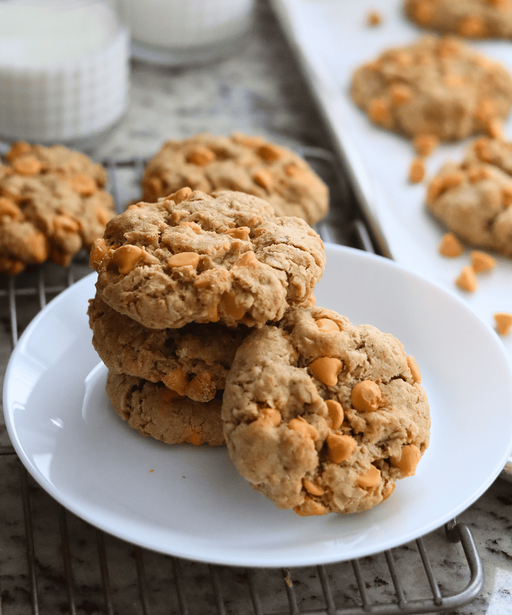Sourdough Oatmeal Butterscotch Cookies stacked with two glasses of milk