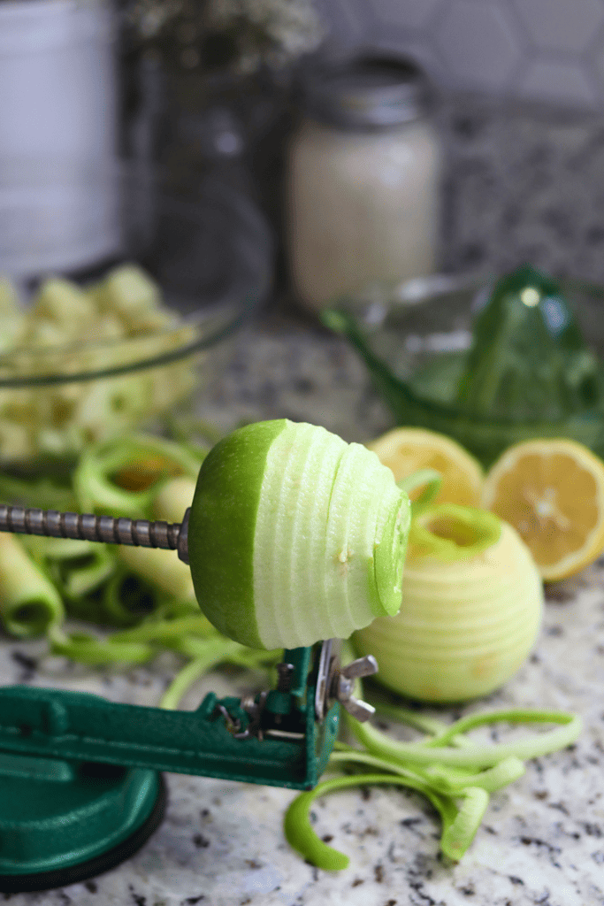 Granny Smith apple being peeled by apple peeler