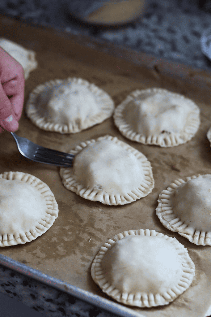 using a fork to crimp the pie crust together for the Sourdough hand pies