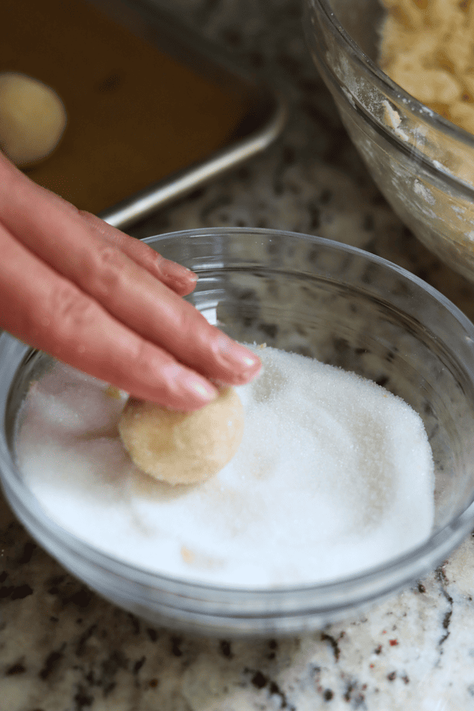Rolling the cookie dough ball in granulated sugar