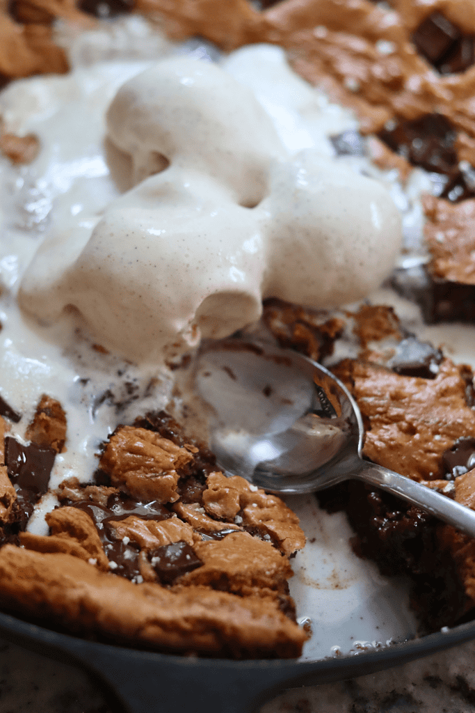spoon scooping out a piece of sourdough chocolate chip skillet cookie