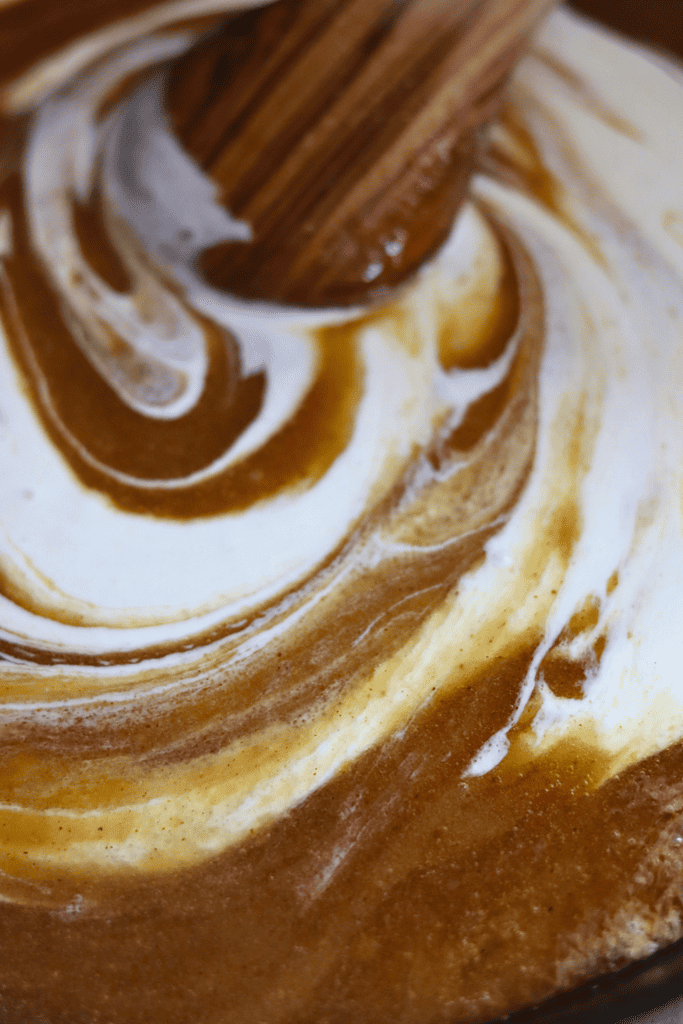 stirring in sourdough discard with a wooden spoon