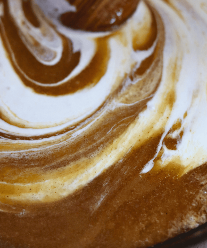 stirring in sourdough discard with a wooden spoon