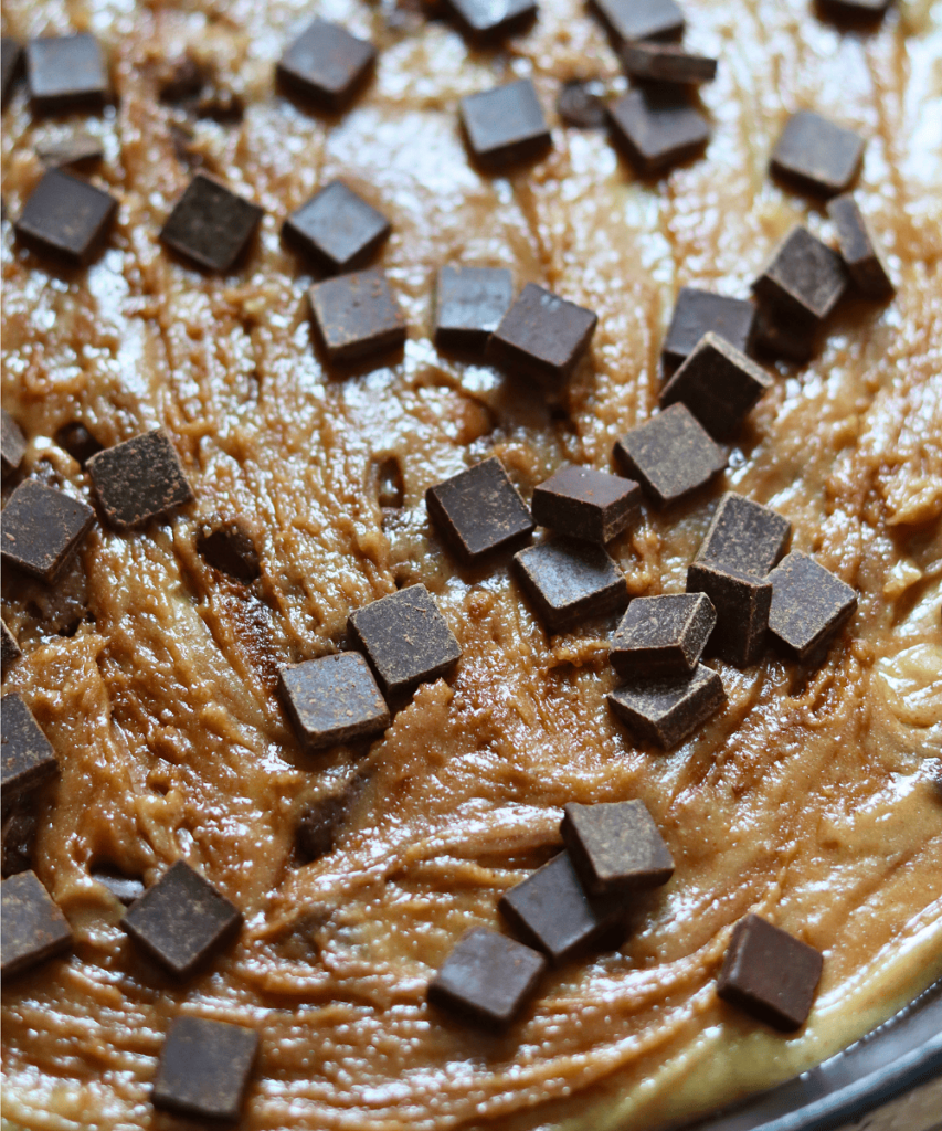 topping the cookie dough with more dark chocolate chunks