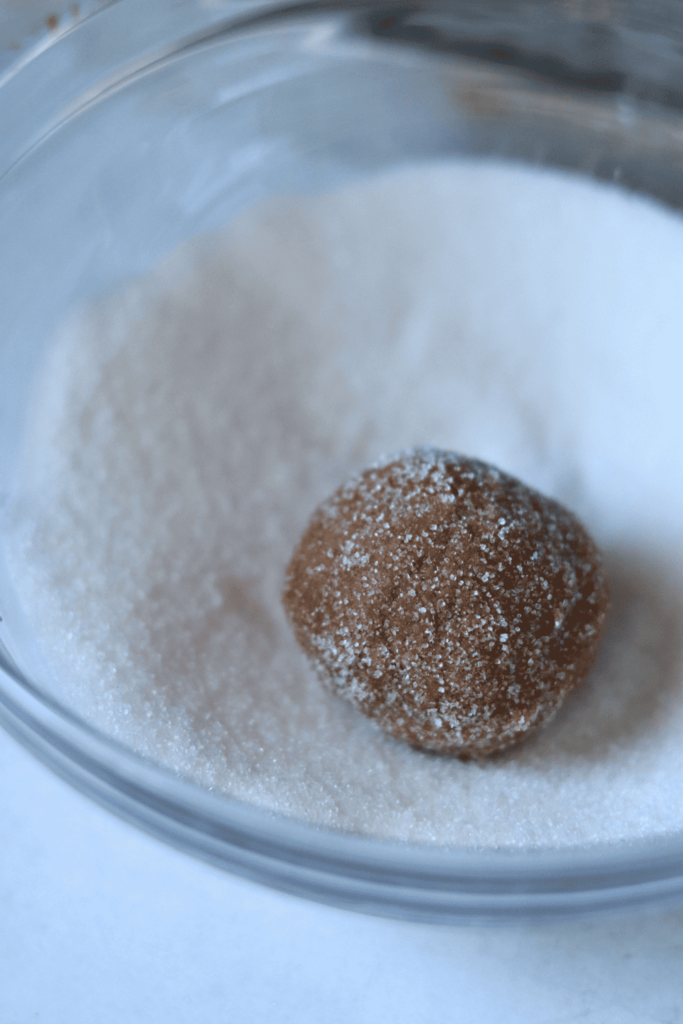 Sourdough Brown Sugar Cookie dough ball in a bowl of sugar