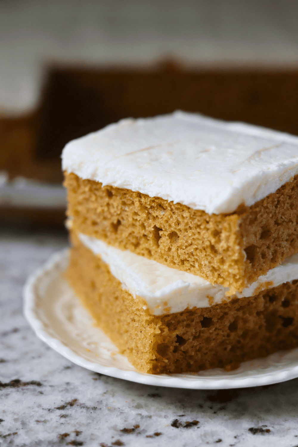 Pieces of Sourdough Pumpkin Sheet Cake stacked on top of one another