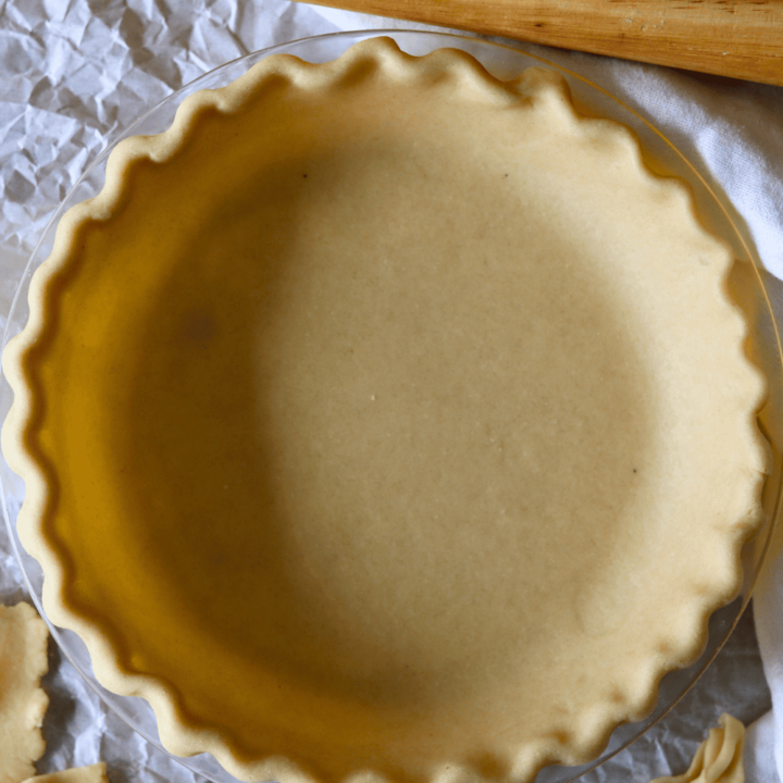 Sourdough Discard Pie Crust in a pie plate with a rolling pin near by