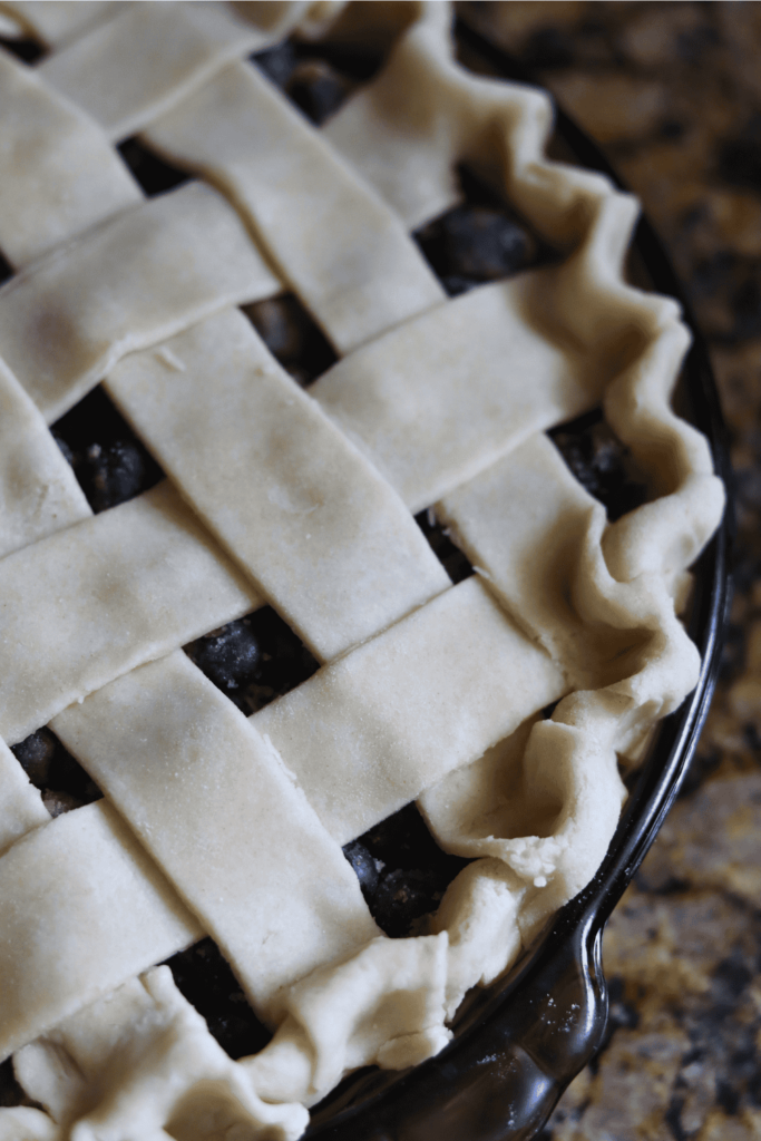 pinching the edge of the pie to seal it
