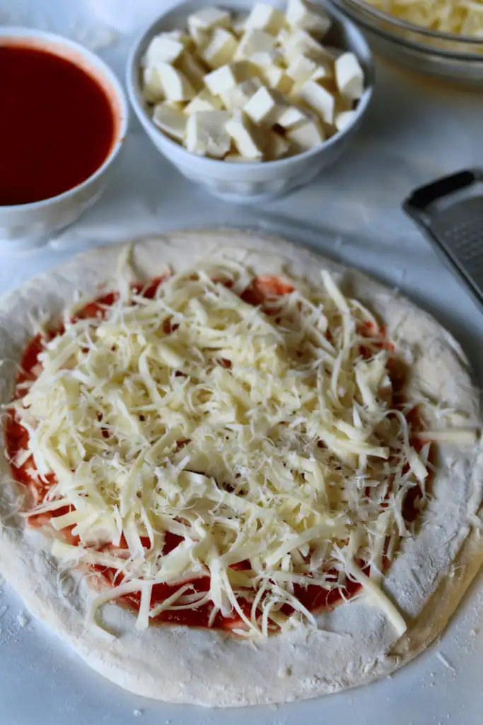pizza dough topped with sauce and cheese