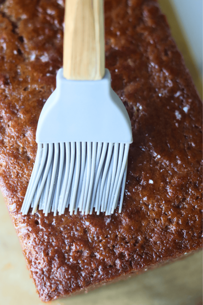 apple cider donut bread loaf being brushed with melted butter