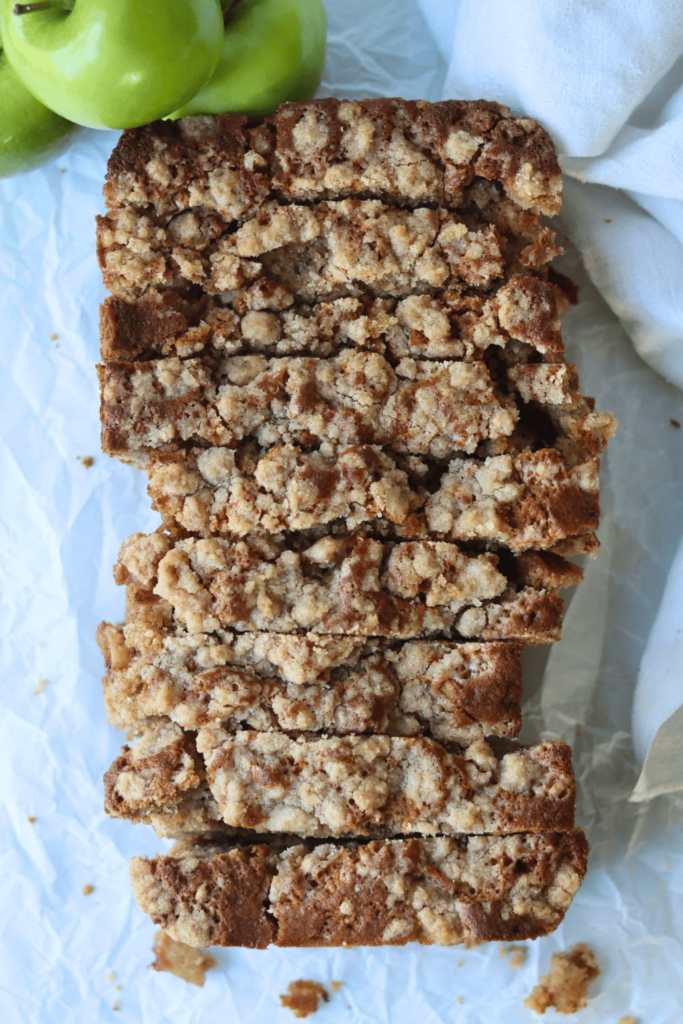 A loaf of apple cinnamon quick bread sliced into thick pieces,