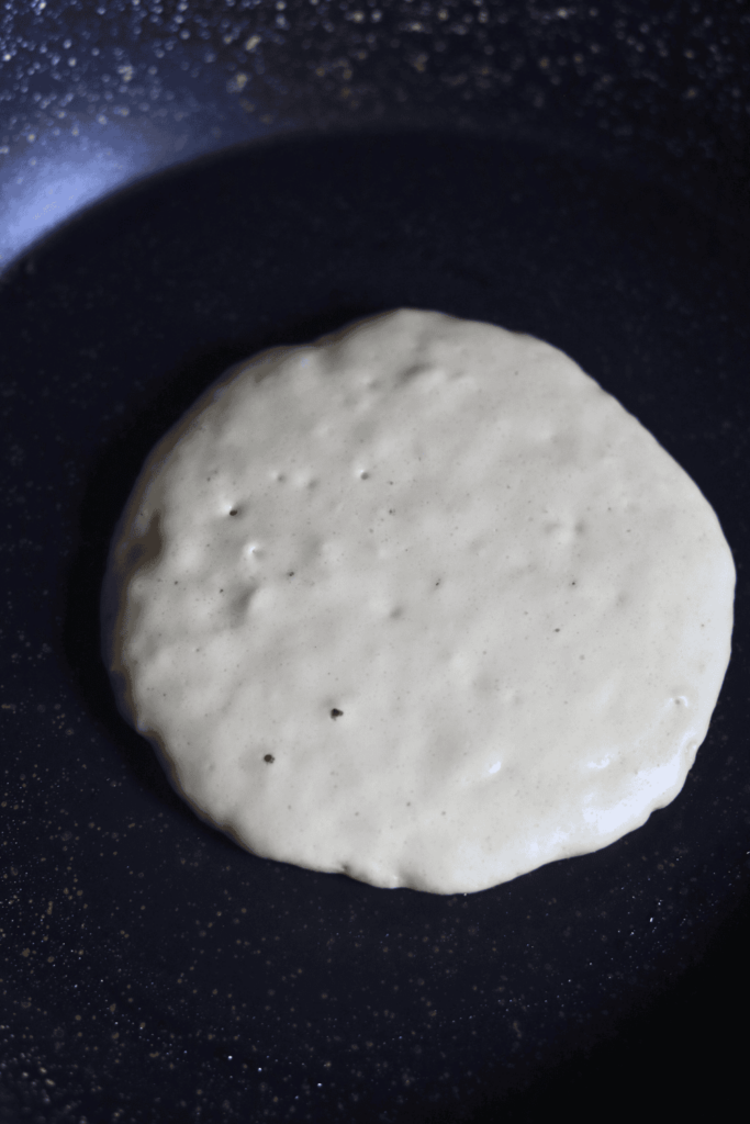 pancake batter being cooked on a skillet