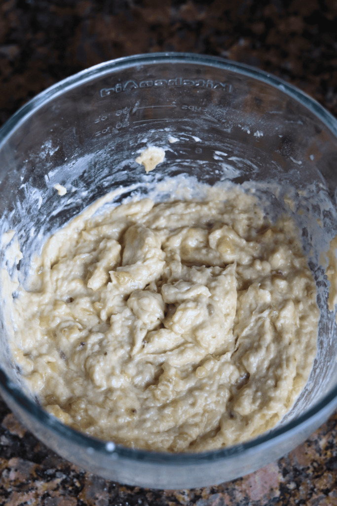 dry ingredients with crushed banana in glass bowl