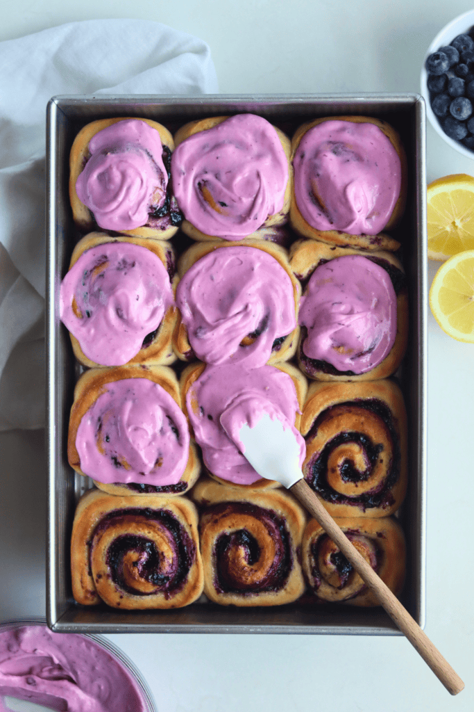 spreading frosting in on the rolls