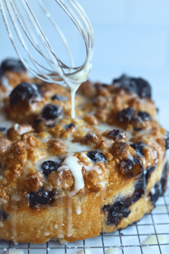pouring lemon glaze onto the focaccia