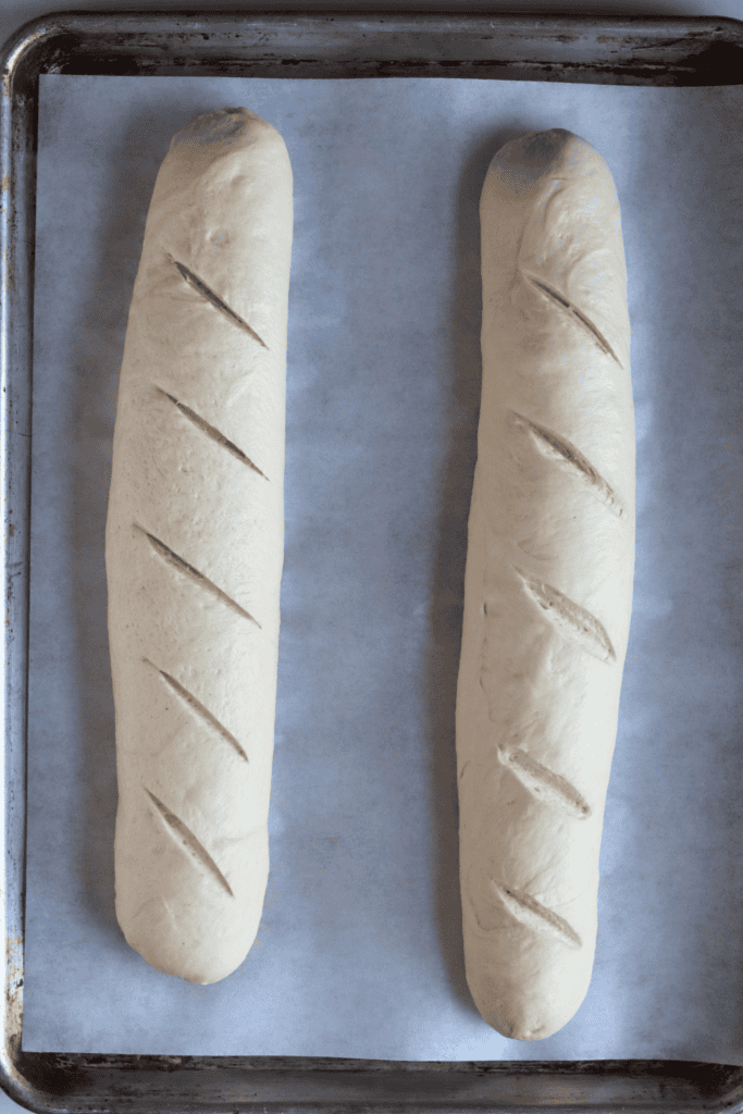 shaped dough on a baking sheet with slashes