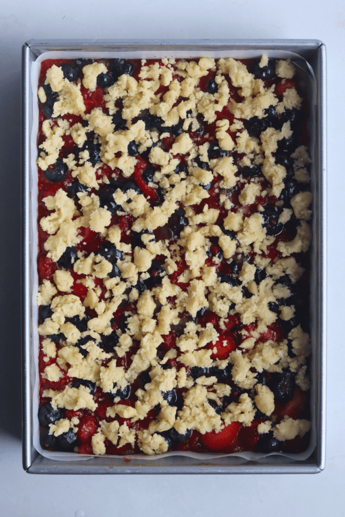 adding the crumble on top of the berry mixture