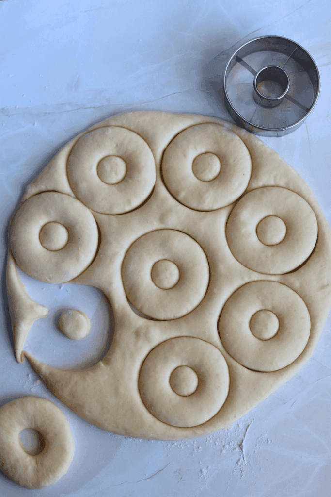 cutting the dough with a donut cutter