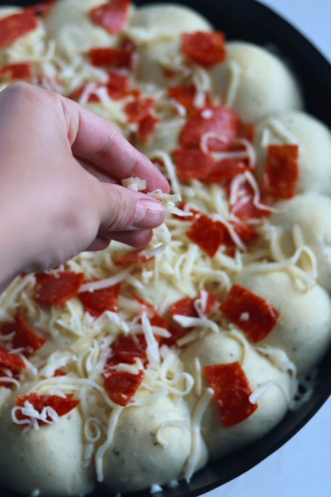 adding toppings to the pull apart rolls