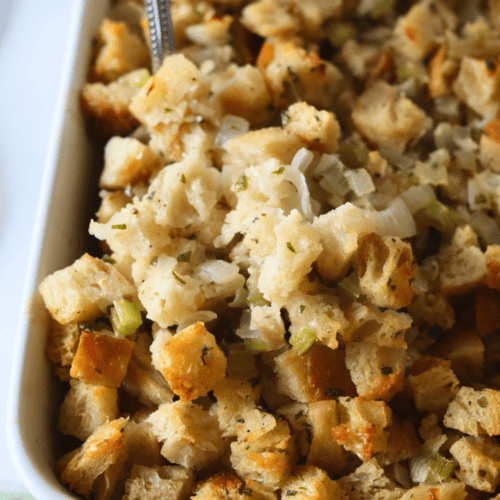 Thanksgiving side dish of sourdough dressing in a white casserole dish.