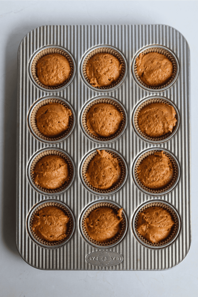 sourdough pumpkin cream cheese muffin batter into the muffin tin