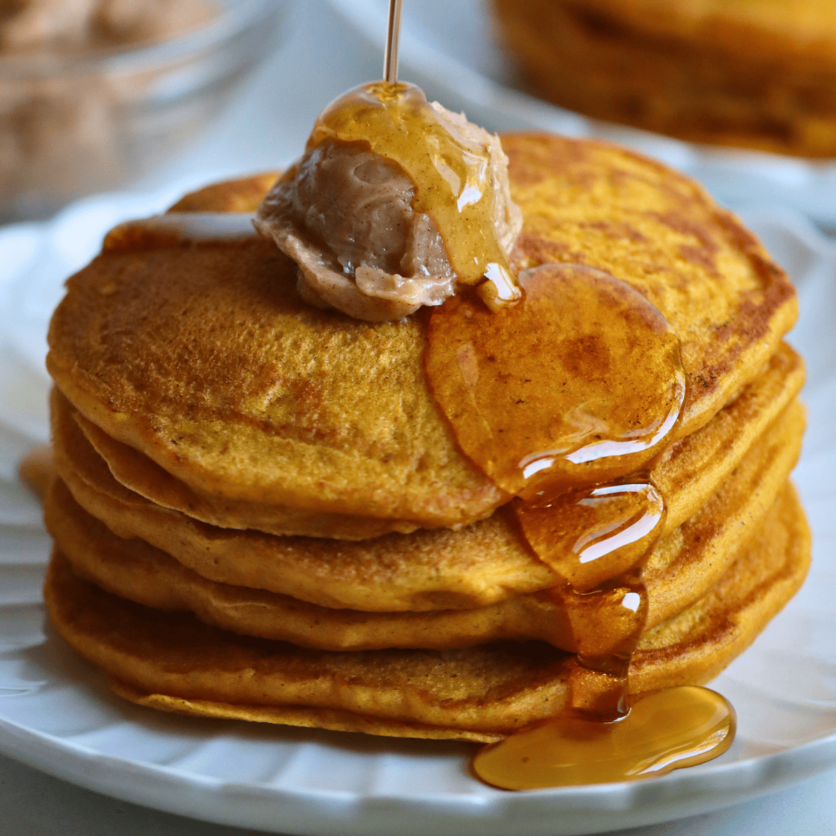 a stack of fluffy sourdough pumpkin pancakes with syrup